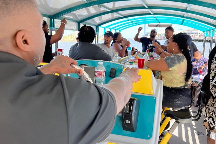 Group of people enjoying a social gathering on a boat with colorful roof.